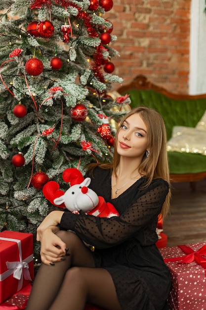 Beautiful young girl near the Christmas tree