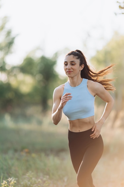 Beautiful young girl runs in the park in a tshirt sports running health