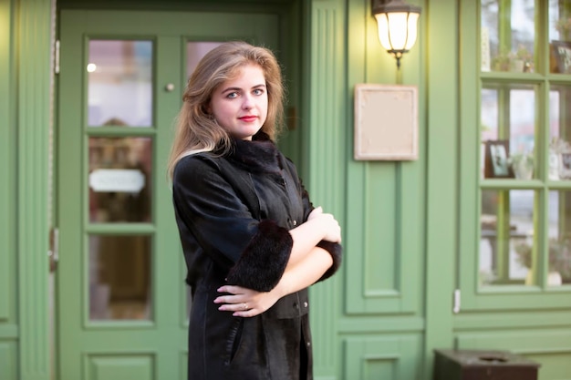 A beautiful young girl stands at the door of the cafe