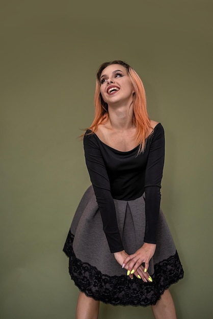 Beautiful young girl in a stylish new female image posing on a green background Concept of woman portrait on monochrome background