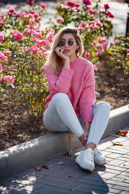 Beautiful young girl on a walk in the autumn city Beautiful woman in a sweater Fashion portrait stylish pretty woman outdoor Young woman having fun in city Street fashion