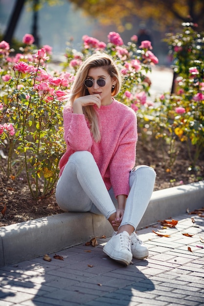 Beautiful young girl on a walk in the autumn city Beautiful woman in a sweater Fashion portrait stylish pretty woman outdoor Young woman having fun in city Street fashion