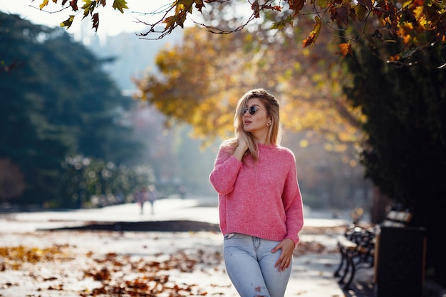 Beautiful young girl on a walk in the autumn city Beautiful woman in a sweater Fashion portrait stylish pretty woman outdoor Young woman having fun in city Street fashion