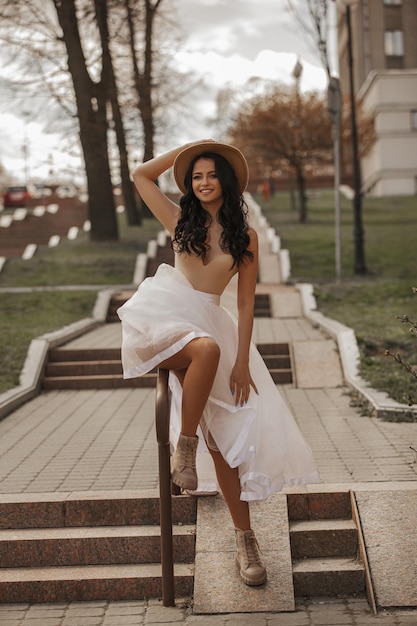 beautiful young girl walking around the city in a white skirt and hat