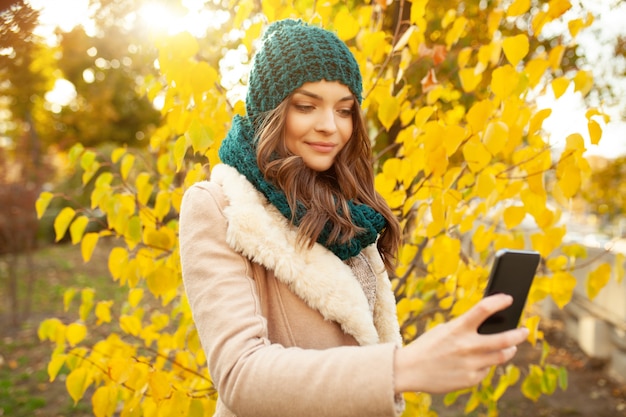 A beautiful young girl walks through the autumn park 