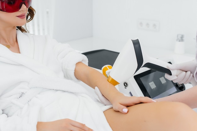 A beautiful young girl will undergo laser hair removal with modern equipment in a Spa salon