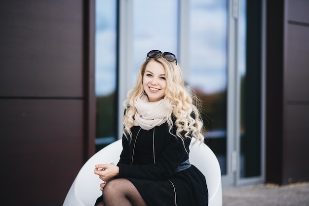 Beautiful young girl with blonde wavy hair outdoors