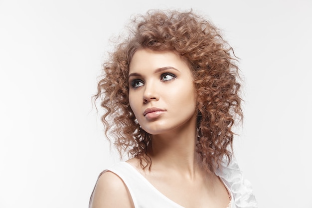 A beautiful young girl with curly hair on white background