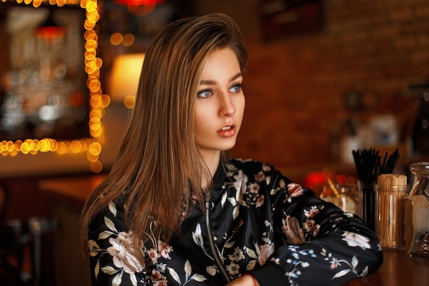 Beautiful young girl with a cute face relaxing in a cafe.