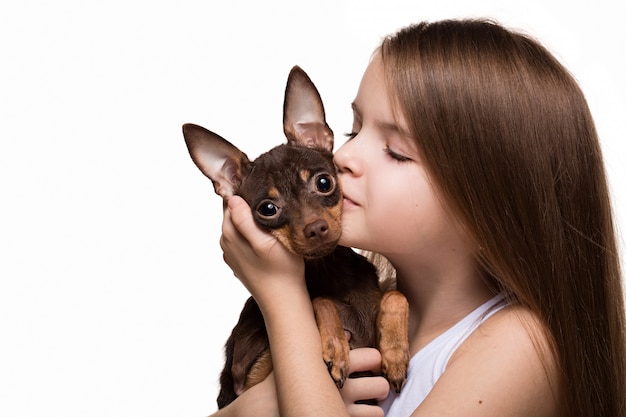 Beautiful young girl with cute terrier dog, isolated on white.