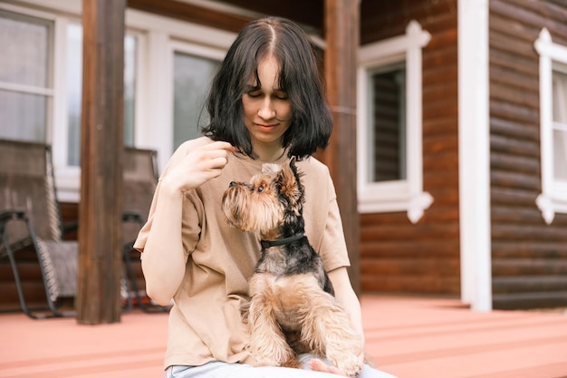 The beautiful young girl with a dog in the street Yorkshire Terrier Girl on a walk with fluffy friend