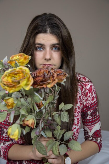 Beautiful young girl with holding a bouquet of dried flowers