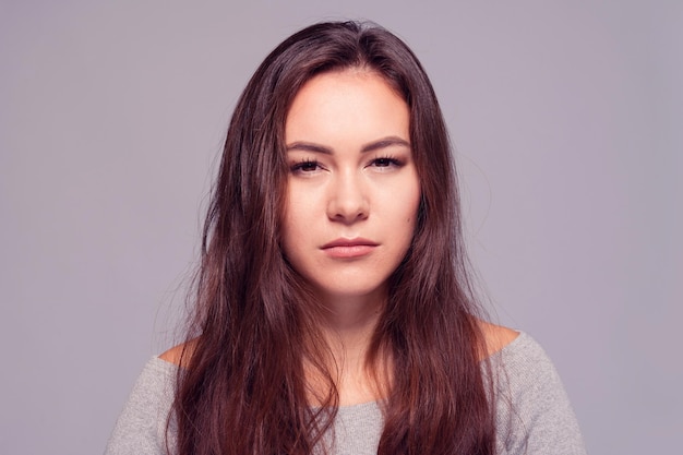 Beautiful young girl with long dark hair intently looking into the camera