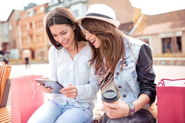 Beautiful young girls in the city drinking coffee to go