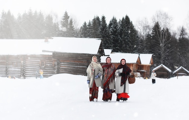 Beautiful young girls in traditional costumes of the Russian north in winter