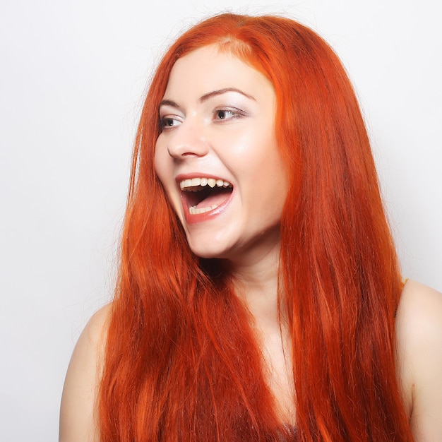 Beautiful young happy woman with long flowing red hair