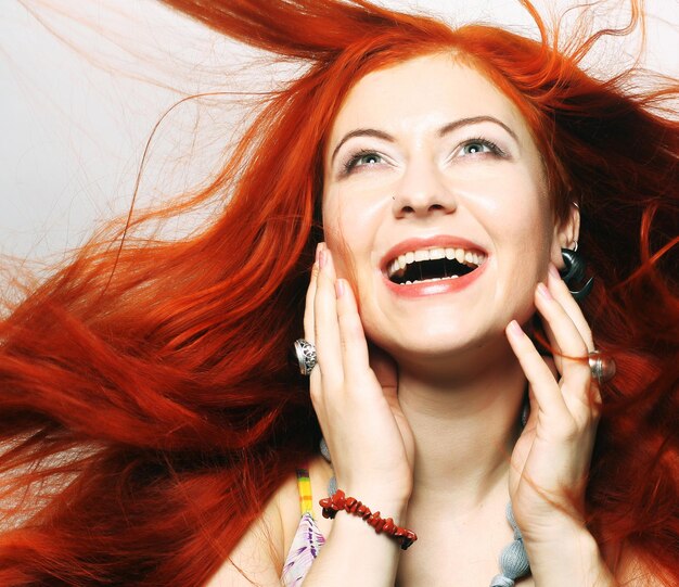 Beautiful young happy woman with long flowing red hair