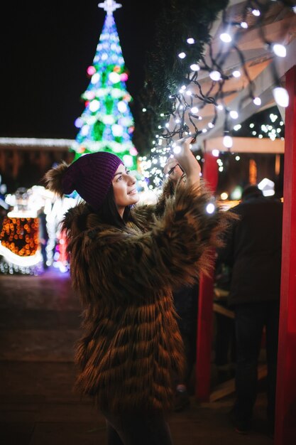 The beautiful young lady standing near Christmas fair