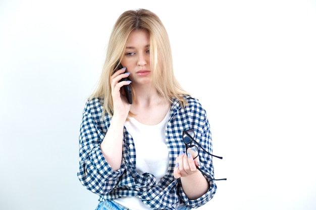 Beautiful young lady talking on phone, holding glasses