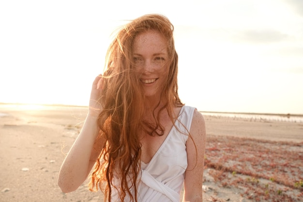 Beautiful young lady with long healthy red hair and cute dress