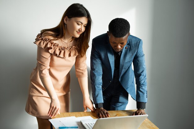 beautiful young man and woman working in office with laptop