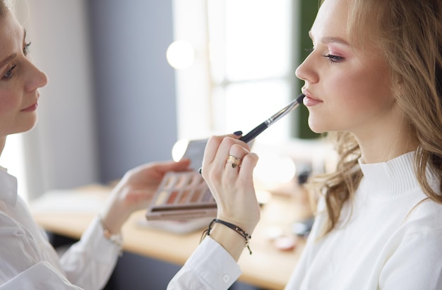 Beautiful young model woman getting fashion makeup