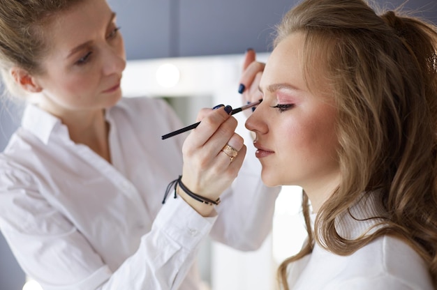 Beautiful young model woman getting fashion makeup