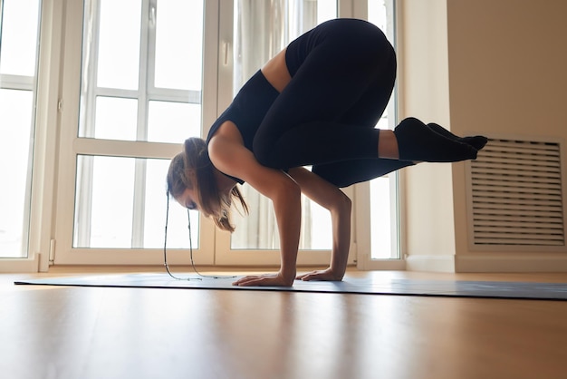 Beautiful young model working out at home doing fitness exercise on floor paripurna navasana for upp