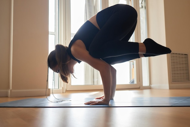 Beautiful young model working out at home doing fitness exercise on floor paripurna navasana for upp