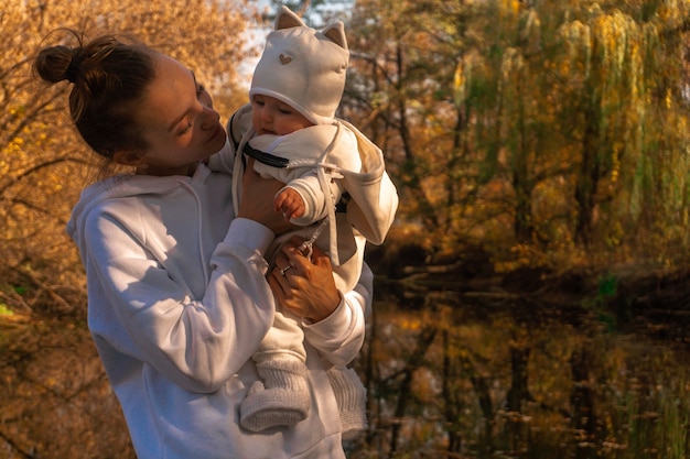 Beautiful young mom with baby girl in autumn