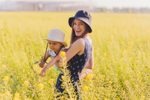 Beautiful young mother and her daughter having fun at the wheat field.