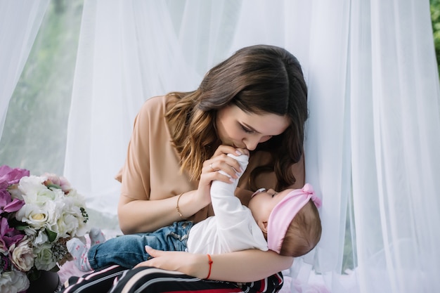 Beautiful young mother kissing her baby girl