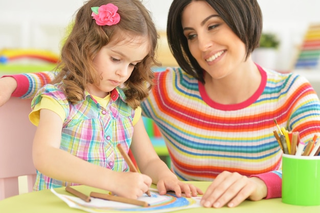 Beautiful young mother playing with her cute little daughter