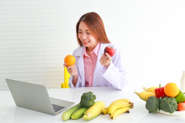 Beautiful young nutritionist who takes care of the health of patients Provide food advice to patients through laptop computers healthy food choices concept by a doctor consulting