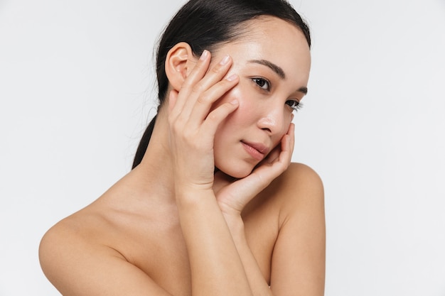 beautiful young pretty asian woman with healthy skin posing naked isolated over white wall.