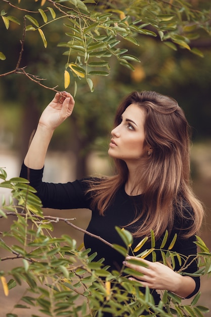 Beautiful young smiling brunette woman  in autumn park