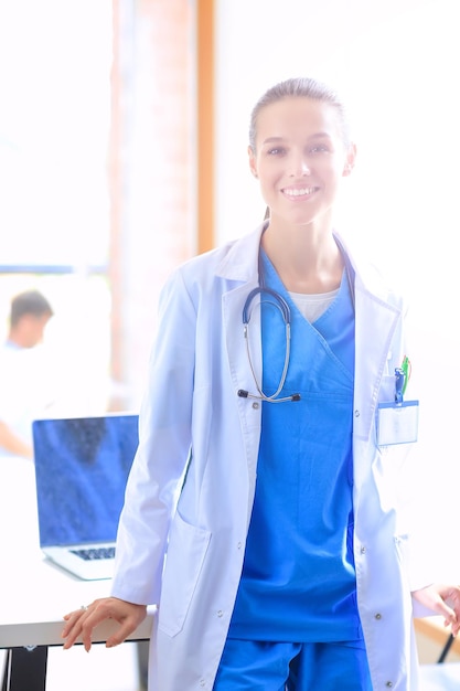 Beautiful young smiling female doctor sitting at the desk Woman doctor