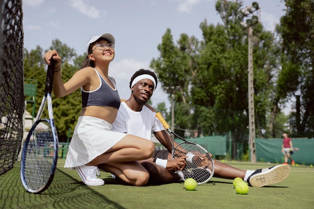 Beautiful and young students take photo after playing tennis they won