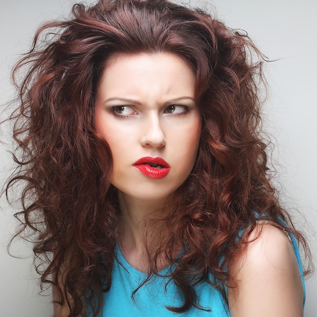 Beautiful young surprised woman. Studio shot.