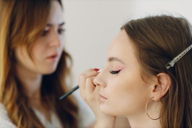 Beautiful young woman applying makeup beauty visage brush