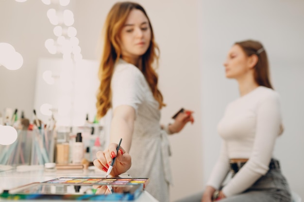 Beautiful young woman applying makeup beauty visage brush