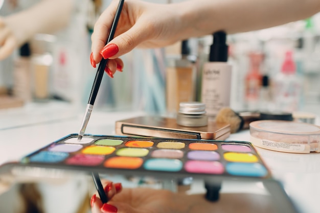 Beautiful young woman applying makeup beauty visage brush