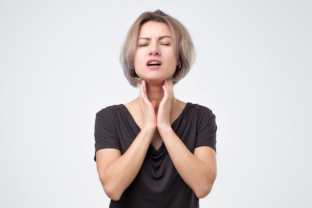 Beautiful young woman in black tshirt has a sore throat