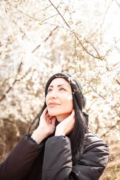 Beautiful young woman in blooming cherry blossoms garden