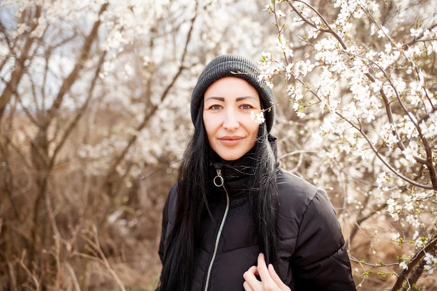 Beautiful young woman in blooming cherry blossoms garden