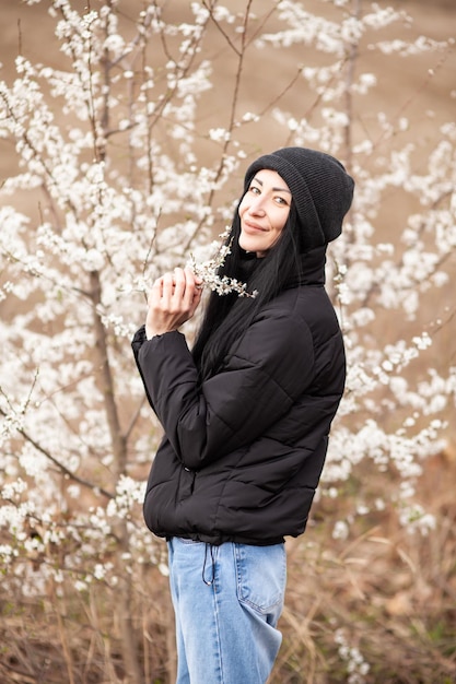 Beautiful young woman in blooming cherry blossoms garden