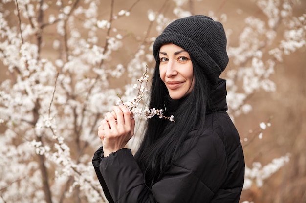 Beautiful young woman in blooming cherry blossoms garden