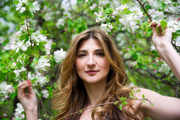 Beautiful young woman in blossoming garden