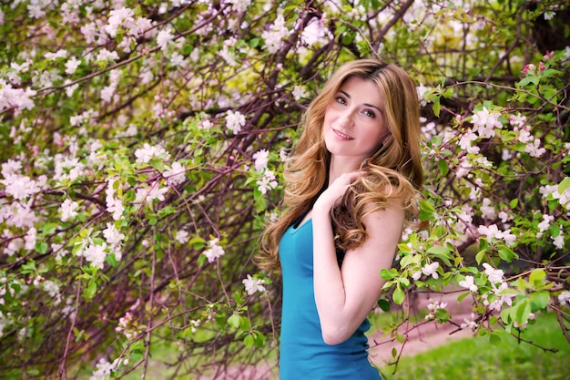 Beautiful young woman in blossoming garden