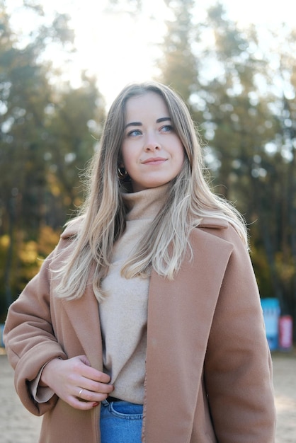 Beautiful young woman in brown coat enjoying the weather Slow living Enjoying the little things Lykke concept